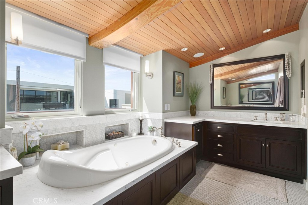 401 27th Street Manhattan Beach, CA 90266 - Photo 31 of 36 a spacious bathroom with a granite countertop tub sink and mirror