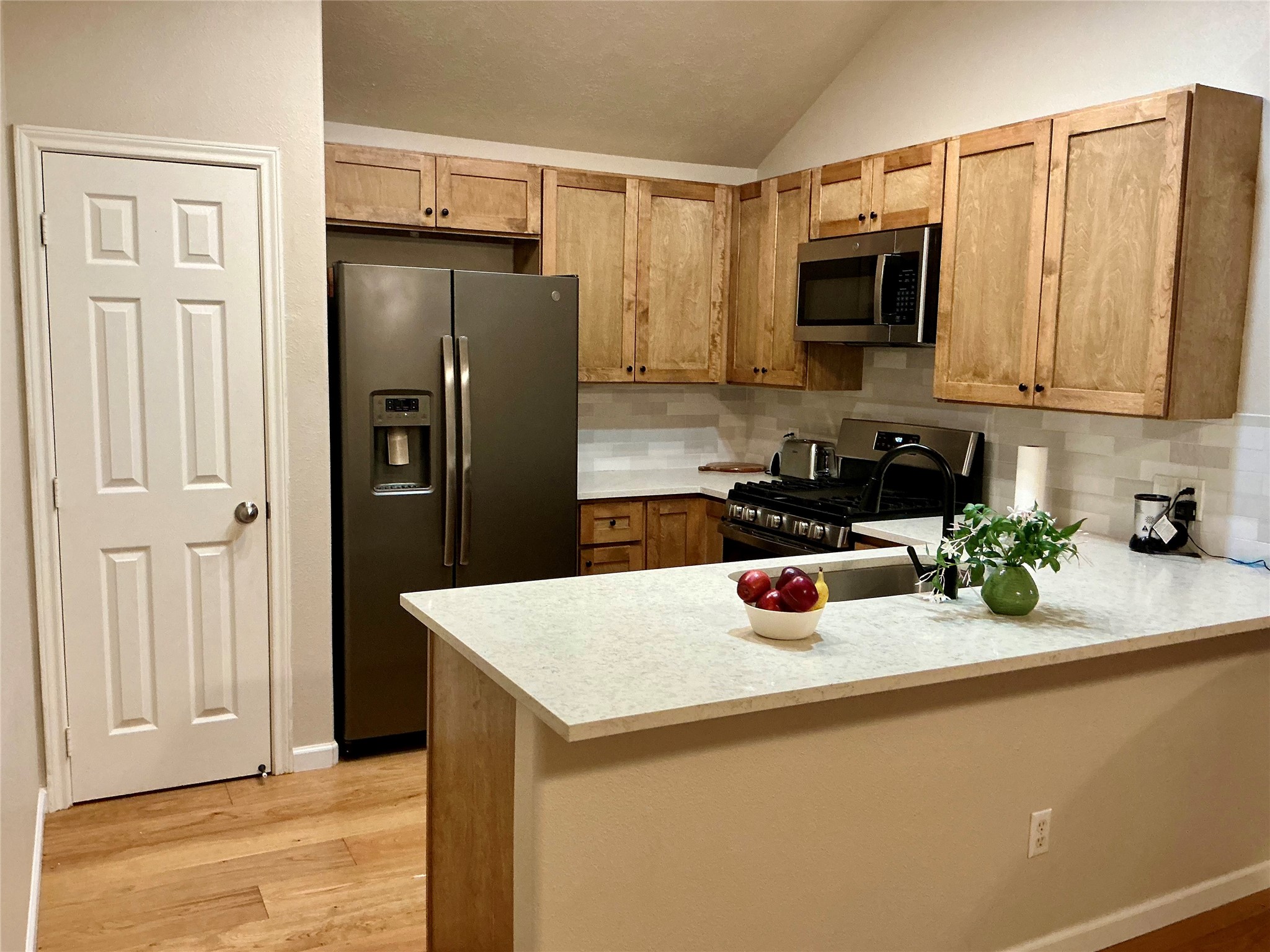 2910 Crescent Bend Road Spring, TX 77388 - Photo 6 of 29 This kitchen features a modern design with stainless steel appliances, wooden cabinets, and a spacious countertop. The open layout includes a pantry and a stylish backsplash, enhancing both functionality and aesthetics.
