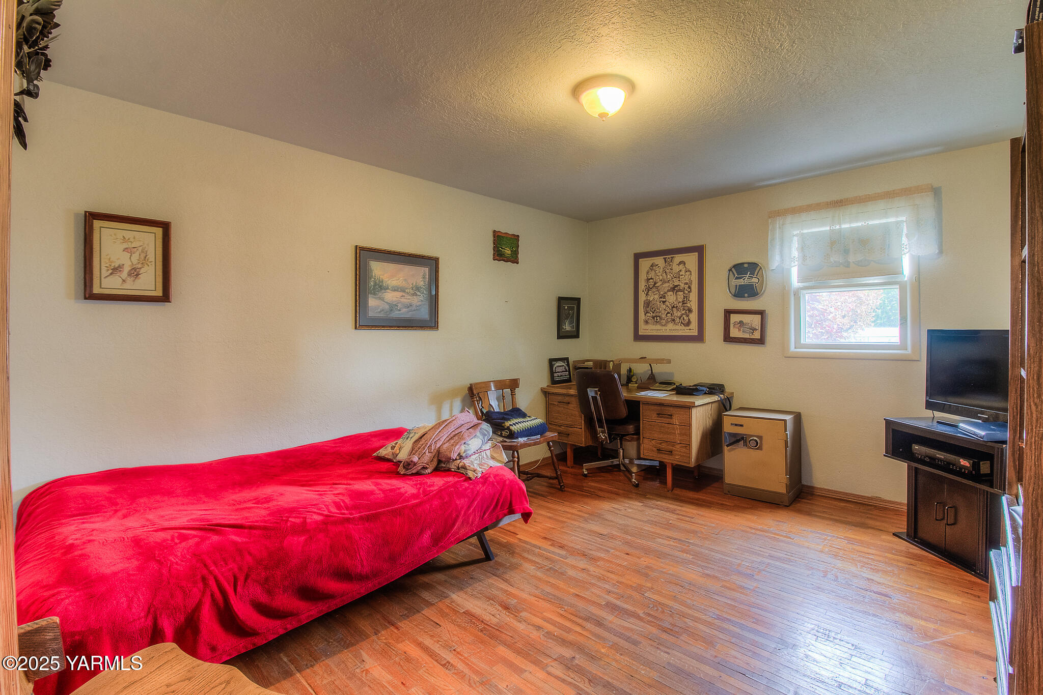 806 Madison Avenue Toppenish, WA 98948 - Photo 18 of 38 a bedroom with a bed and wooden floor