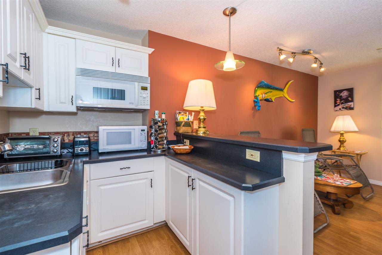71 Valencia Street St. Augustine, FL 32084 - Photo 37 of 43 a kitchen with stainless steel appliances granite countertop a sink a stove and white cabinets