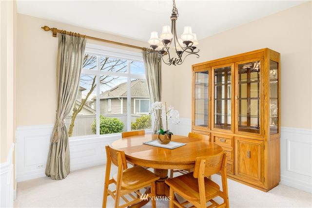 a view of a dining room with furniture a chandelier and wooden floor