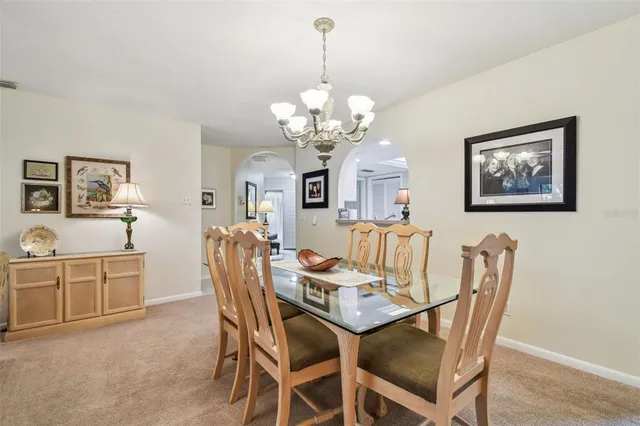 a living room with furniture a chandelier and a flat screen tv