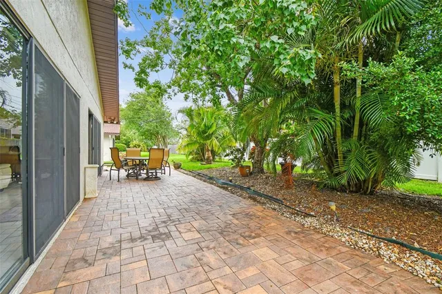 an aerial view of residential houses with outdoor space and trees