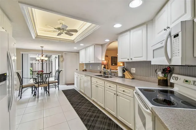 a kitchen with white cabinets and appliances