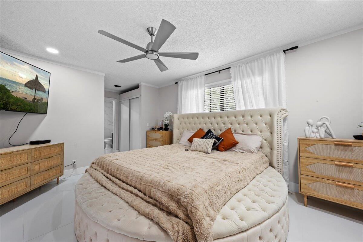 1779 Harborside Circle Wellington, FL 33414 - Photo 12 of 23 a bedroom with a bed and a flat screen tv