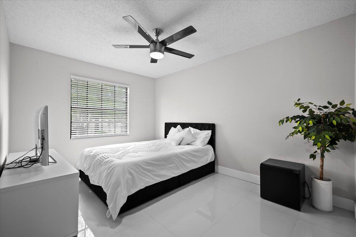 1779 Harborside Circle Wellington, FL 33414 - Photo 18 of 23 a bedroom with a bed and a potted plant