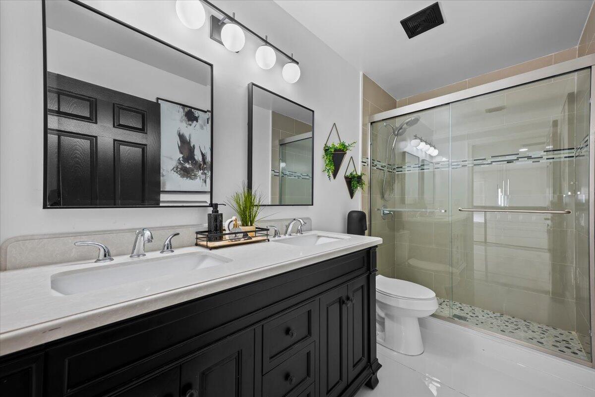 1779 Harborside Circle Wellington, FL 33414 - Photo 19 of 23 a bathroom with a double vanity sink toilet and shower