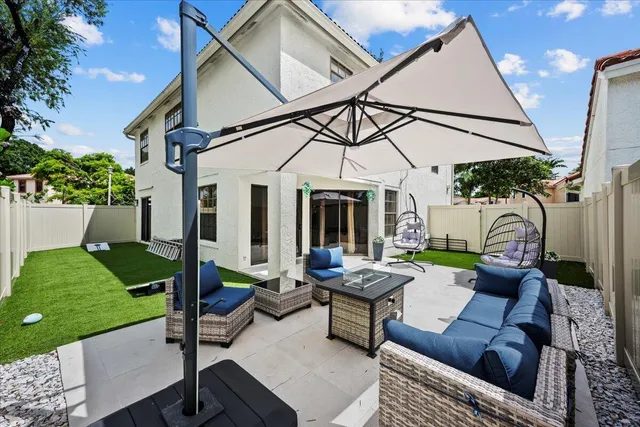 a view of a patio with couches table and chairs with potted plants