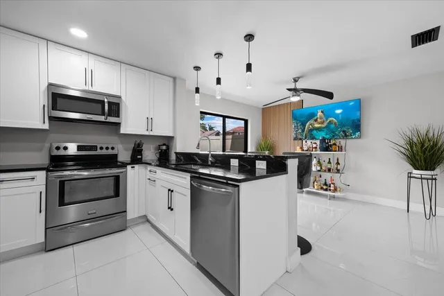 a kitchen with stainless steel appliances granite countertop a stove and cabinets