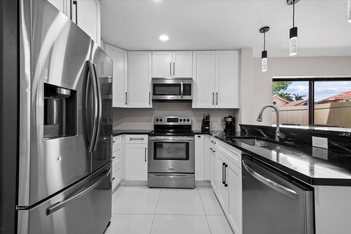 1779 Harborside Circle Wellington, FL 33414 - Photo 9 of 23 a kitchen with stainless steel appliances a refrigerator sink and stove