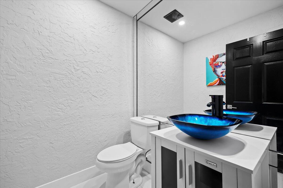 1779 Harborside Circle Wellington, FL 33414 - Photo 10 of 23 a bathroom with a sink a toilet and a mirror