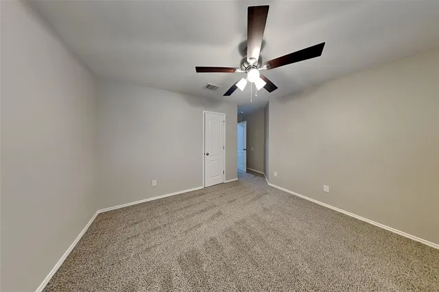 an empty room with a ceiling fan and a fan