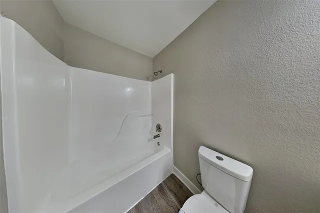 a white toilet sitting next to a bath tub
