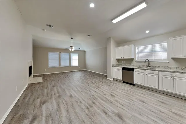 a view of a kitchen with granite countertop stainless steel appliances refrigerator sink and cabinets