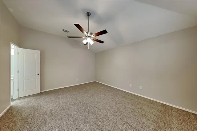 an empty room with a ceiling fan and a window