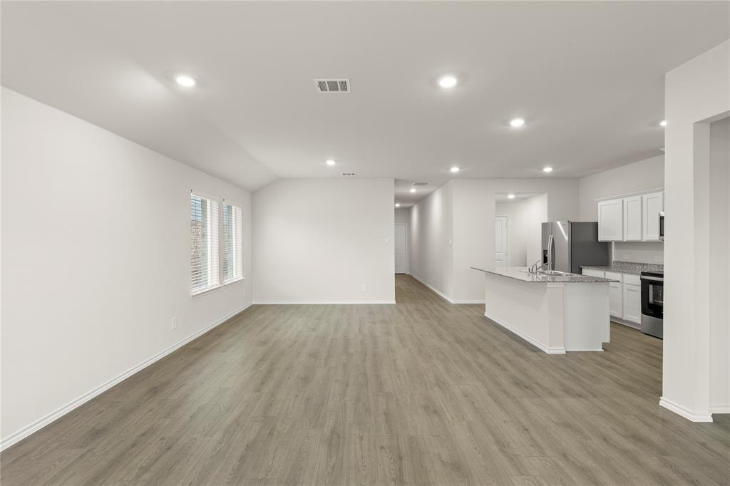 a view of kitchen with kitchen island wooden floors wooden cabinets and living room
