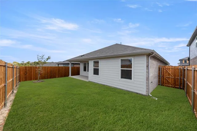 a view of a backyard with plants and large trees