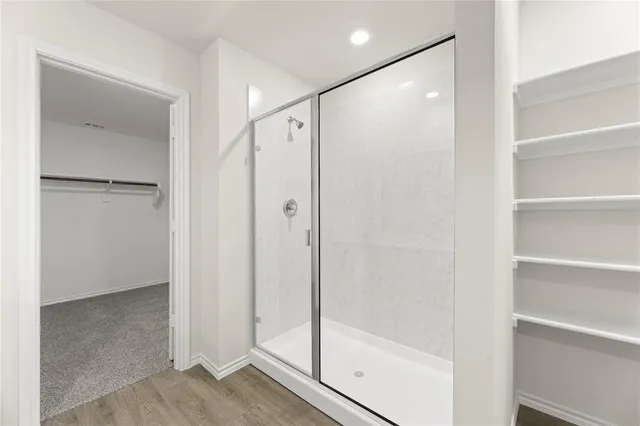 a bathroom with a shower and a glass door