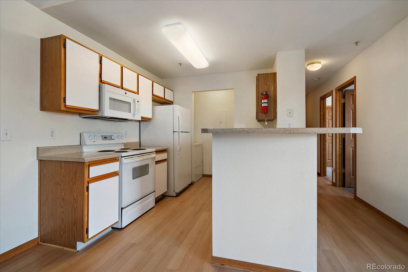 2226 West Elizabeth Street, Unit D302 Fort Collins, CO 80521 - Photo 11 of 20 a kitchen with stainless steel appliances granite countertop a sink stove and a refrigerator