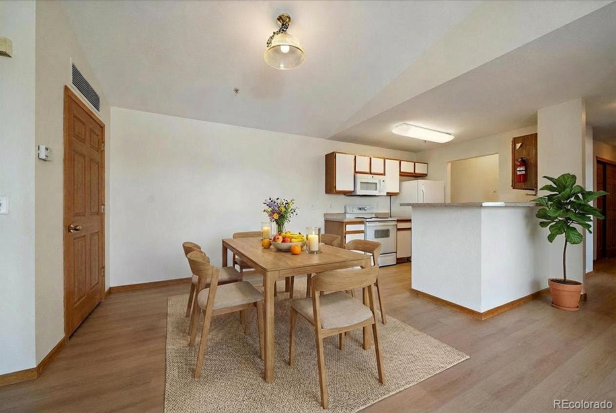 2226 West Elizabeth Street, Unit D302 Fort Collins, CO 80521 - Photo 3 of 20 a view of a dining room with furniture and a potted plant
