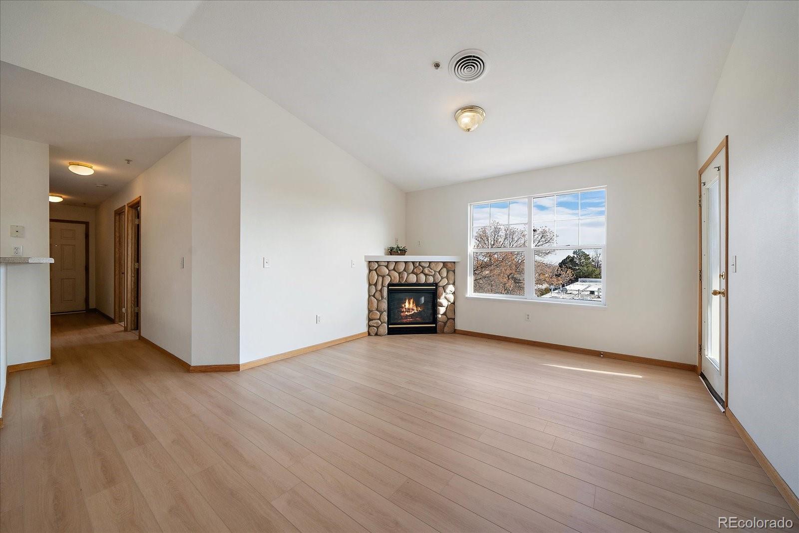 2226 West Elizabeth Street, Unit D302 Fort Collins, CO 80521 - Photo 8 of 20 a view of a livingroom with wooden floor and a refrigerator