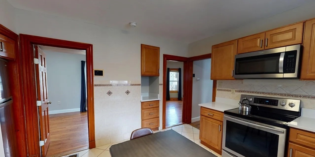a kitchen with stainless steel appliances granite countertop a refrigerator and a stove top oven