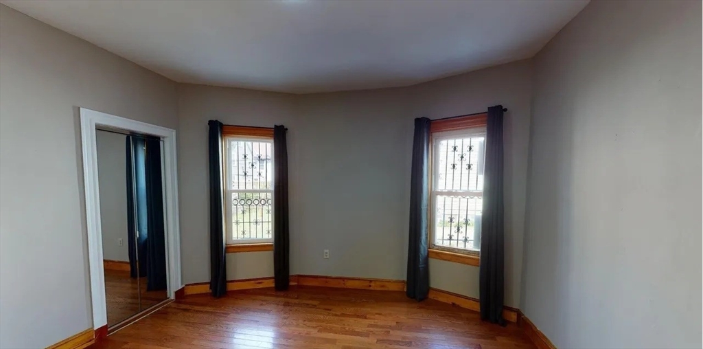 6 Cawfield Street, Unit 3 Boston, MA 02125 - Photo 2 of 9 a view of an empty room with wooden floor and a window