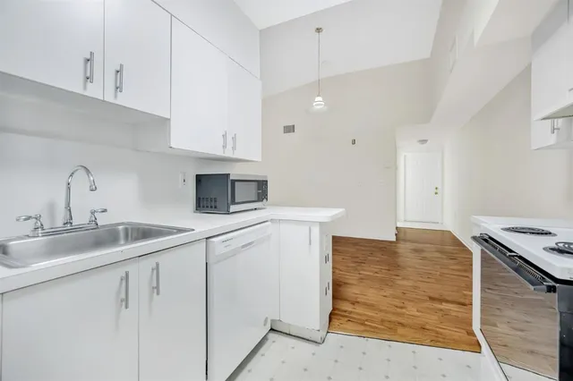 a kitchen with white cabinets and sink
