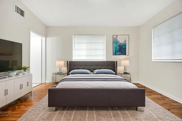 a spacious bedroom with a bed and a flat screen tv