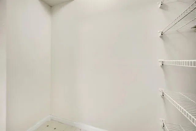 a small space with a white wall and a window