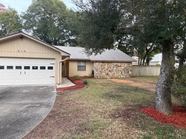 a view of a house with a yard and large tree