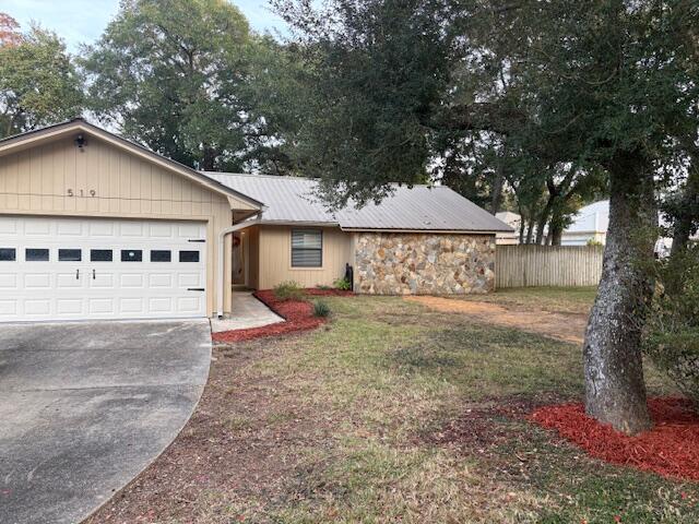 a view of a house with a yard and large tree