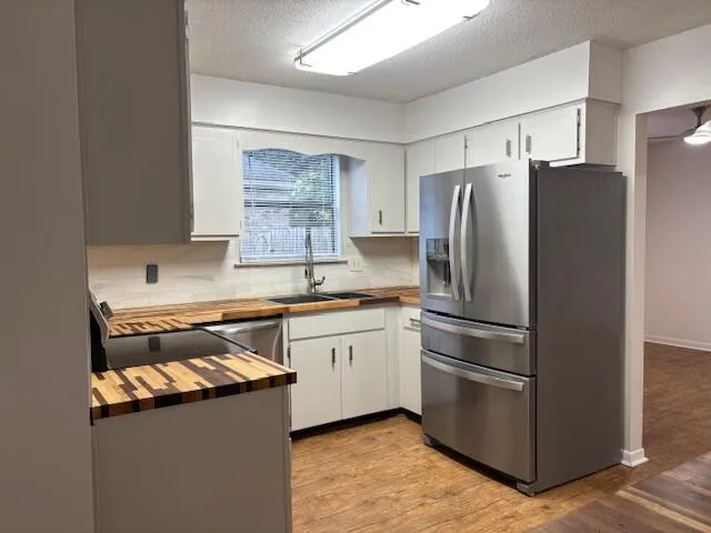 a kitchen with granite countertop white cabinets and stainless steel appliances