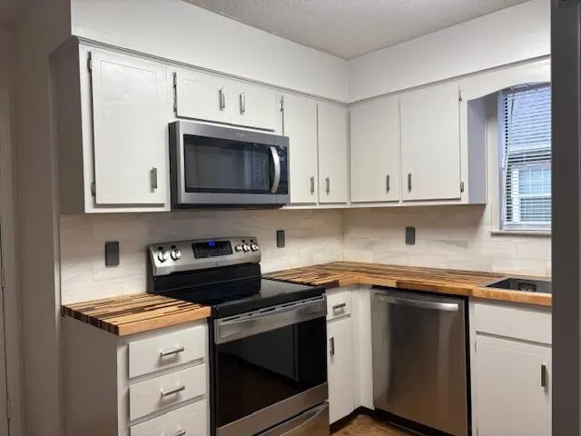a kitchen with cabinets and wooden floor