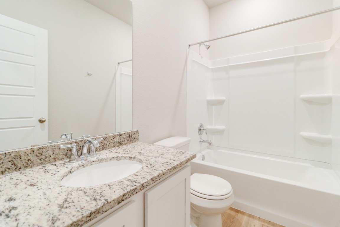 820 Staglin Street, Unit A Buda, TX 78610 - Photo 20 of 28 a bathroom with a granite countertop sink toilet and shower