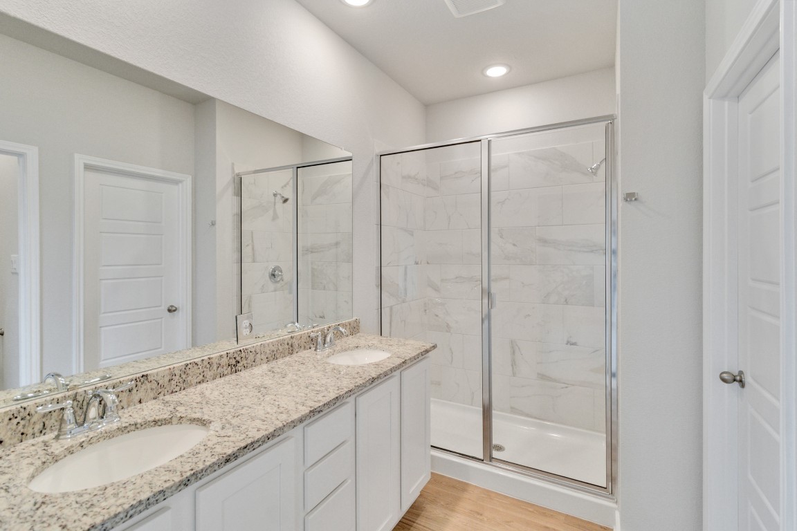 820 Staglin Street, Unit A Buda, TX 78610 - Photo 26 of 28 a bathroom with a granite countertop sink a mirror and shower