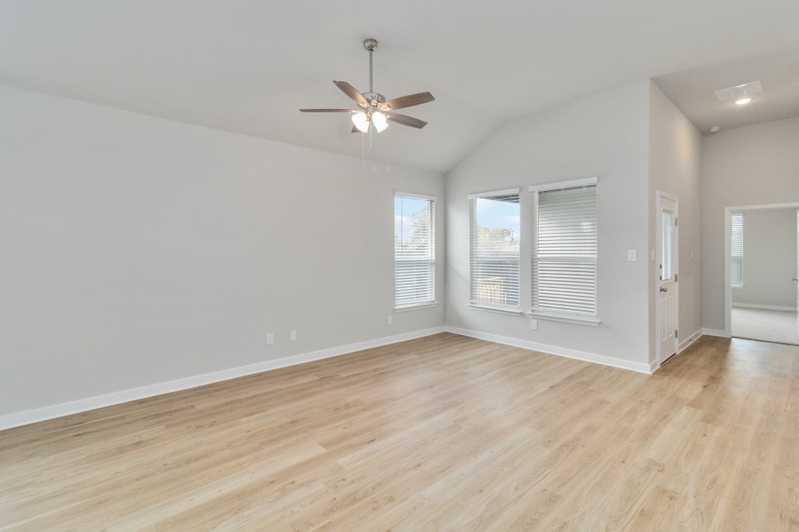 820 Staglin Street, Unit A Buda, TX 78610 - Photo 7 of 28 a view of an empty room with chandelier fan and wooden floor