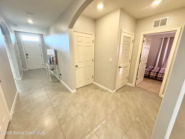 a view of a hallway with closet and a bathroom