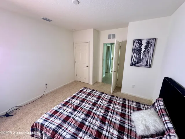 a bedroom with a bed and painting on the wall