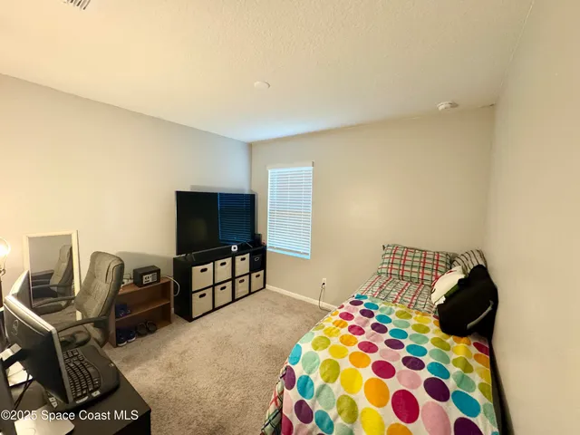 a bedroom with a bed and flat screen tv