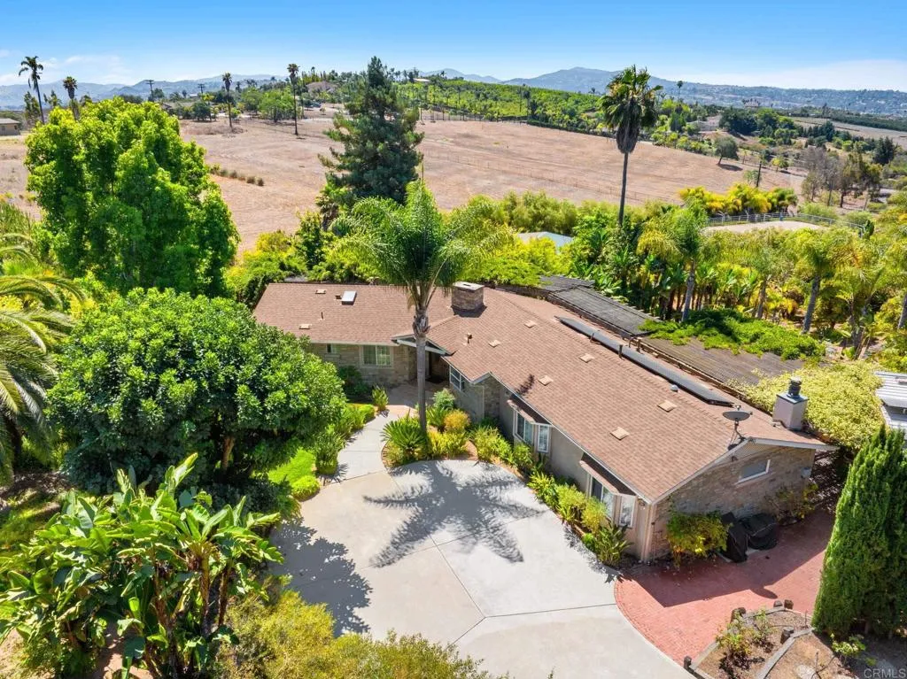31619 Vía Puerta Del Sol Bonsall, CA 92003 - Photo 2 of 70 an aerial view of a house with a garden and lake view