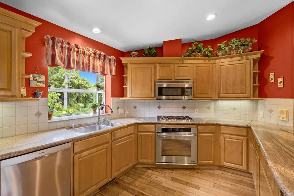 31619 Vía Puerta Del Sol Bonsall, CA 92003 - Photo 43 of 70 a kitchen with stainless steel appliances wooden cabinets and a stove top oven