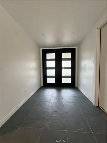 a view of a big room with wooden floor and windows