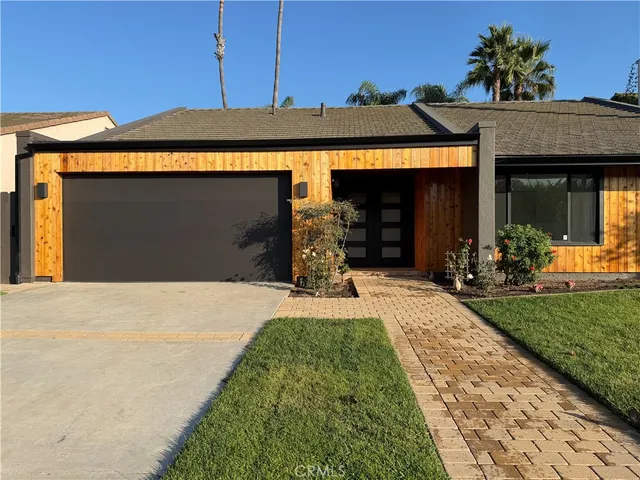 a front view of a house with a garden and yard