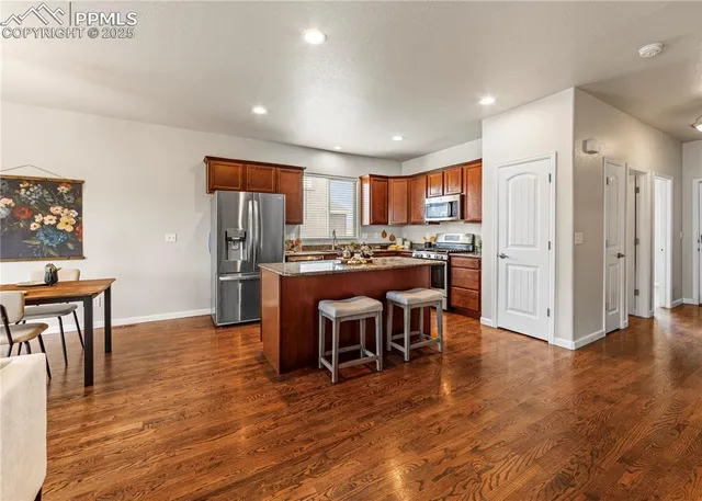 a kitchen with granite countertop stainless steel appliances a sink window and cabinets