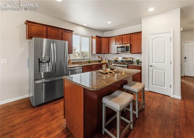 a living room with furniture a rug and kitchen view