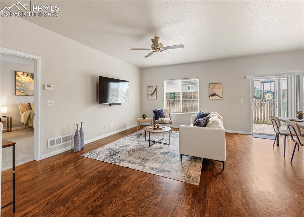 11324 Neutra Grove Peyton, CO 80831 - Photo 20 of 49 a living room with furniture a window and wooden floor