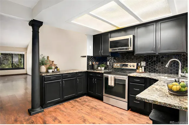a kitchen with stainless steel appliances granite countertop a sink stove and refrigerator