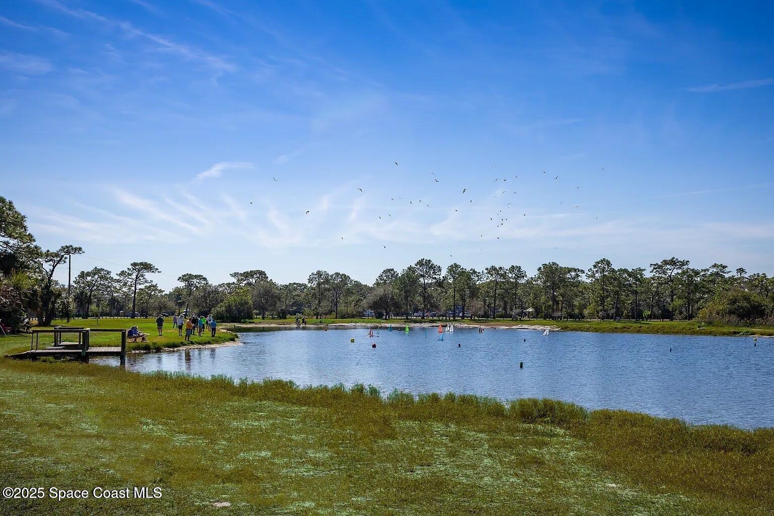 1865 Kendall Pointe Place Melbourne, FL 32935 - Photo 14 of 15 a view of a lake with houses in the back