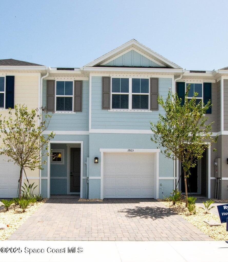1865 Kendall Pointe Place Melbourne, FL 32935 - Photo 2 of 15 a front view of a house with a yard and garage